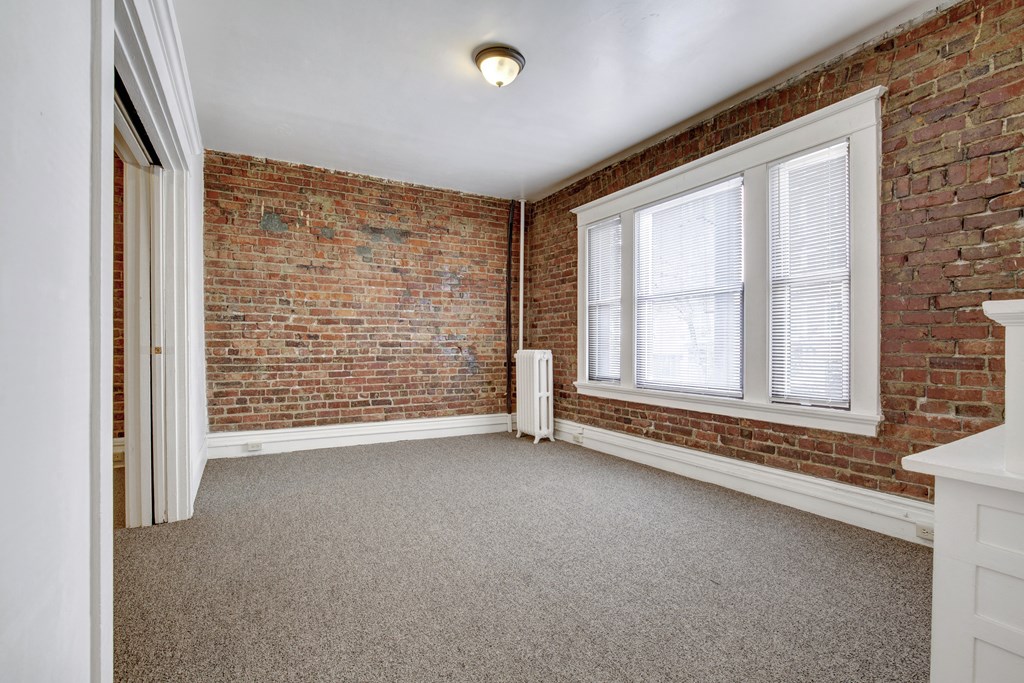 A room with a brick wall and a window.