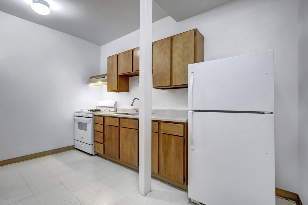 A kitchen with white appliances and wooden cabinets.