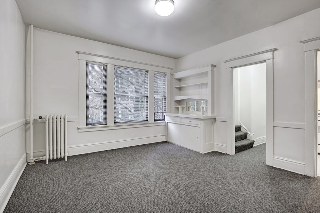 A room with a grey carpet and white walls.