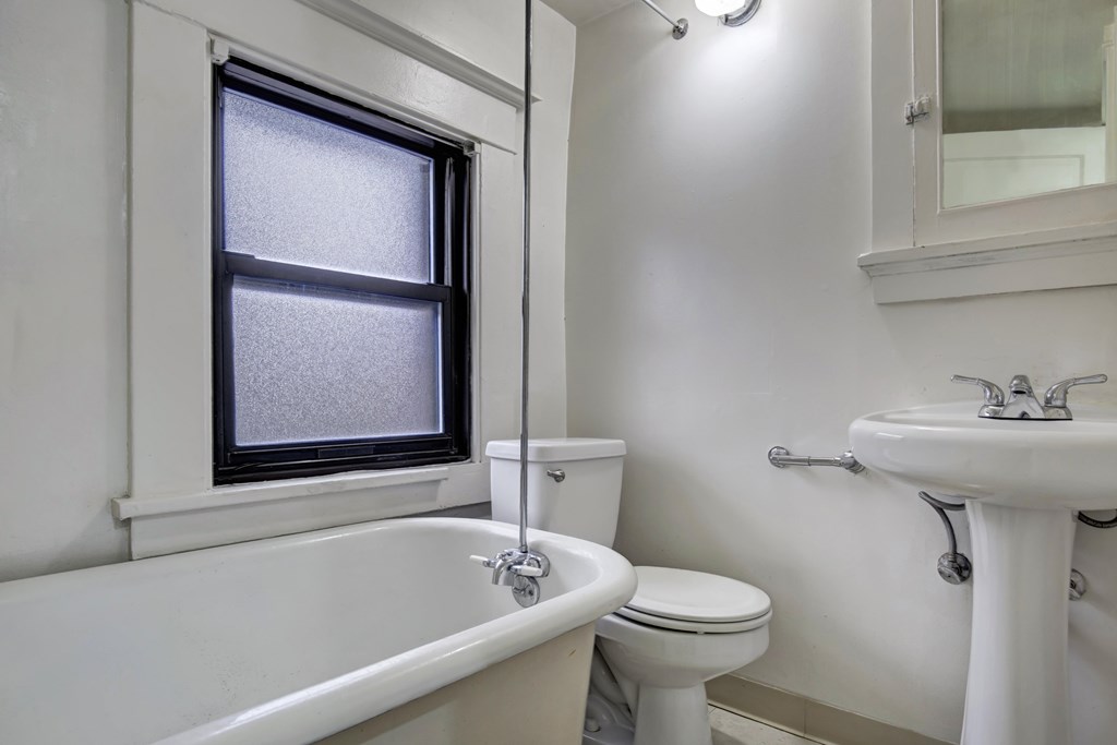 A white bathroom with a toilet, sink, and bathtub.