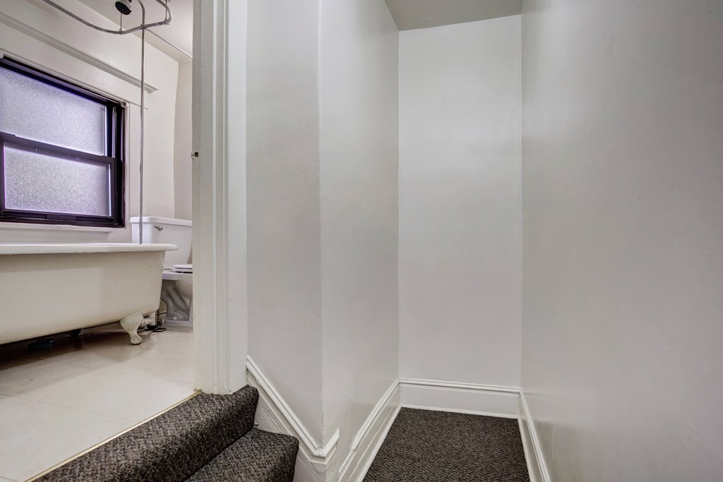 A bathroom with a window and a bathtub.