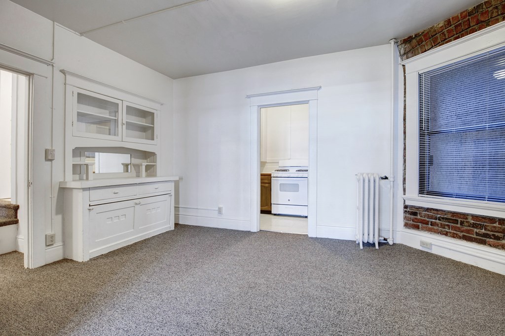 A white kitchen with a white fridge and a white oven.