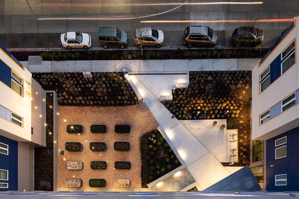 an aerial view of a building with cars parked on the street