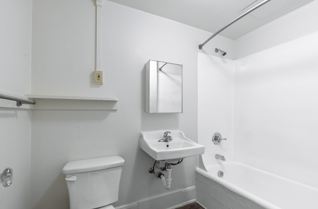 A white bathroom with a toilet, sink, and bathtub.