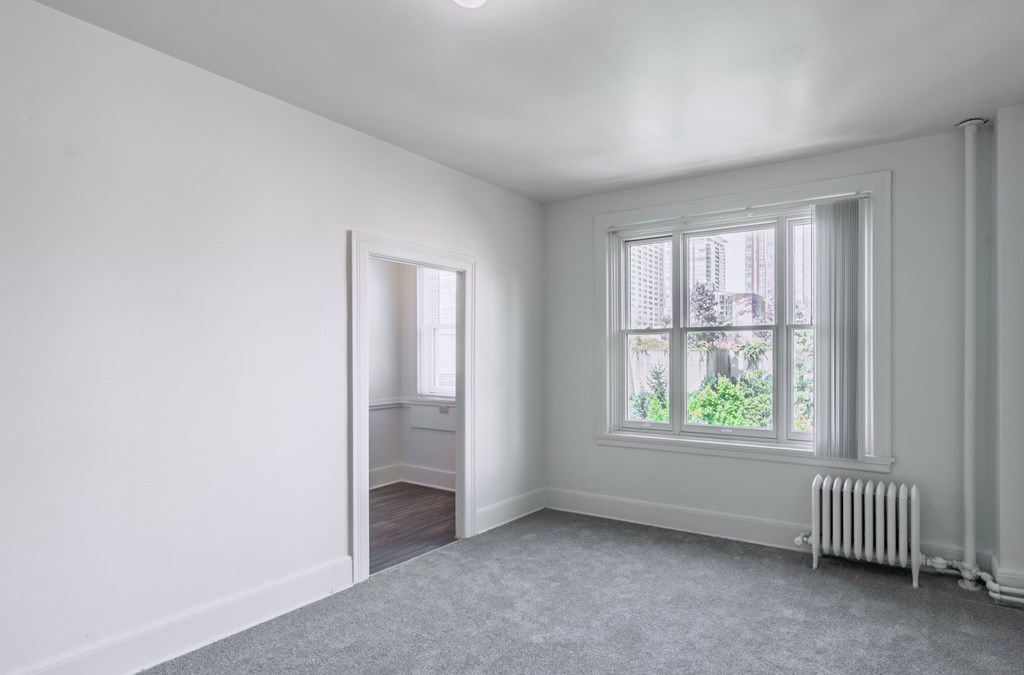 A room with a window and a radiator on the wall.