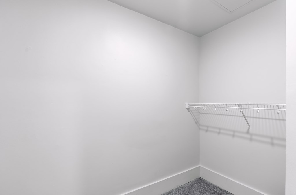 A white wall with a metal rack on it.