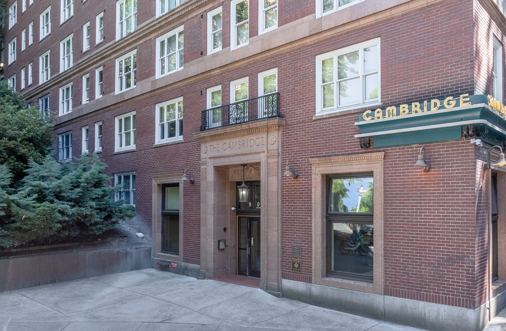 A brick building with a green awning that says Cambridge.