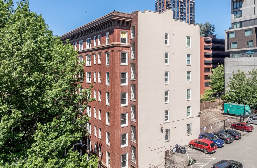 A red brick building with a parking lot in front.