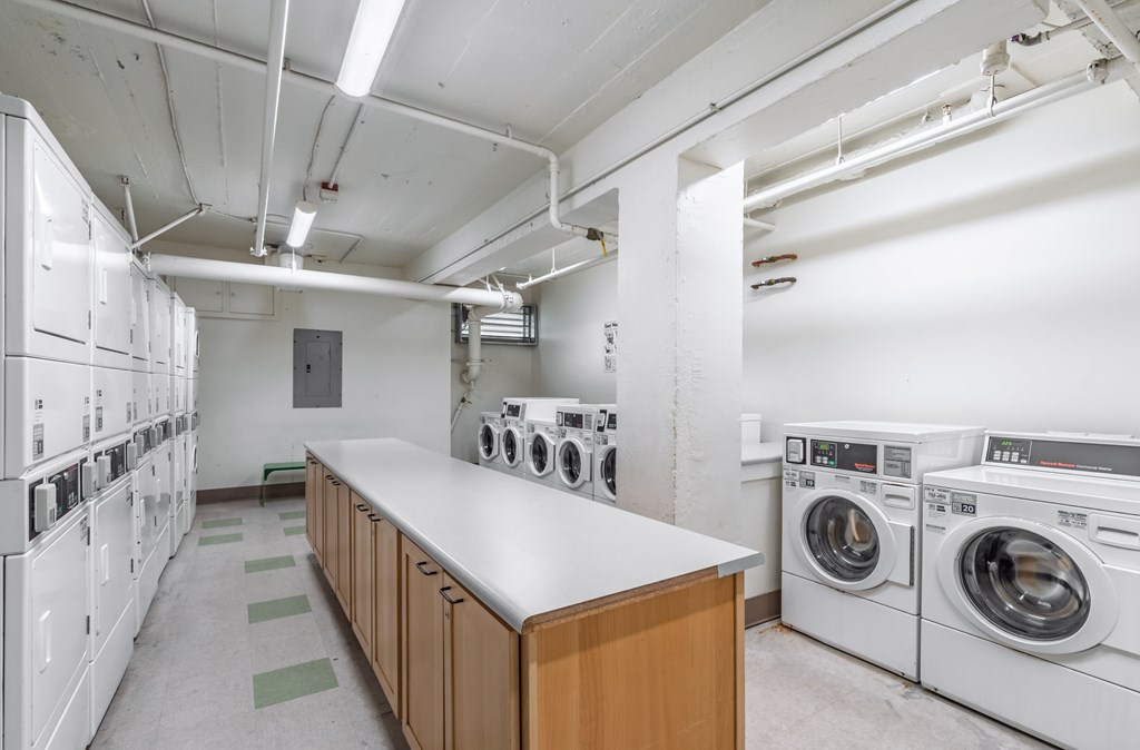 A laundry room with washing machines and a counter.
