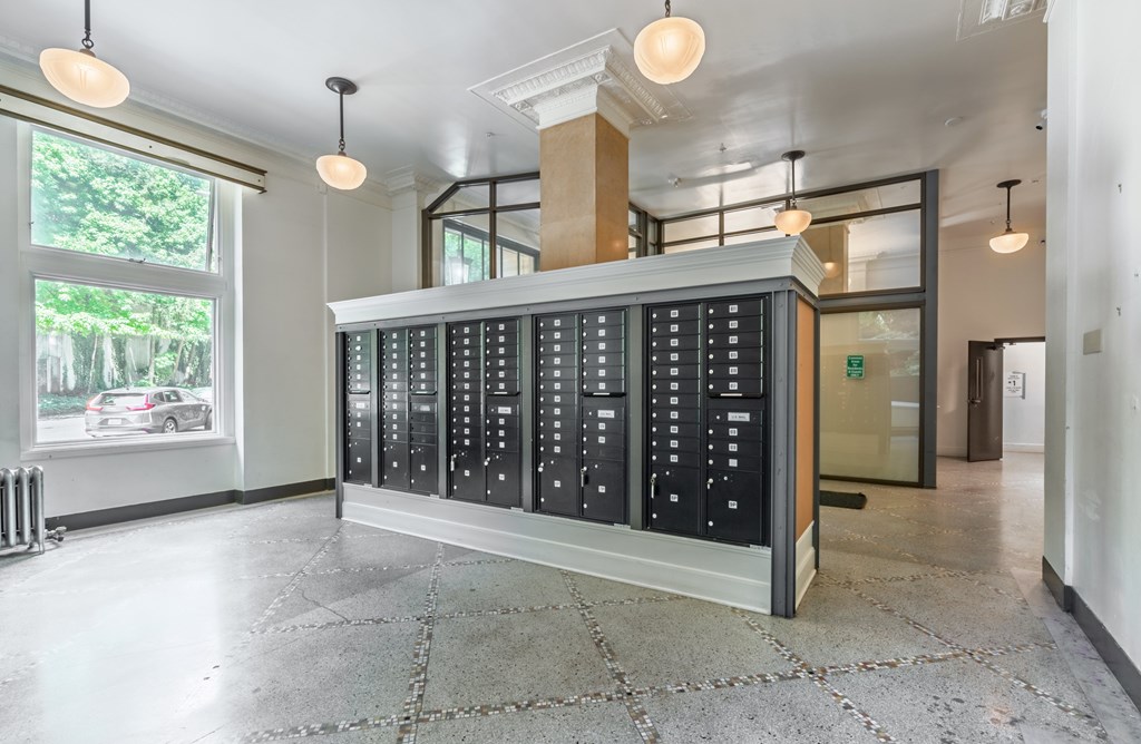 A large, modern, black and white control panel in a spacious room with tiled flooring and large windows.