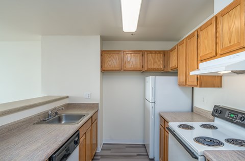 A kitchen with wooden cabinets and a white refrigerator.