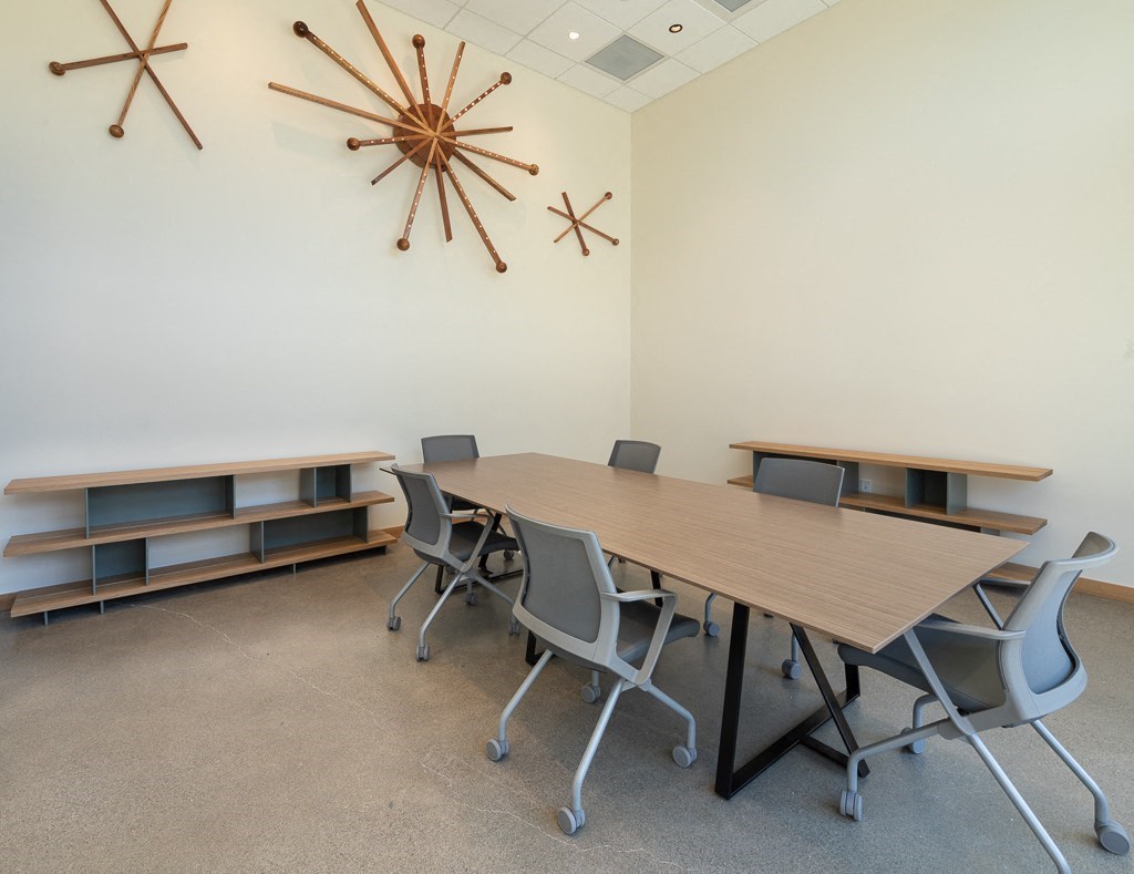 a conference room with a table and chairs and a clock on the wall