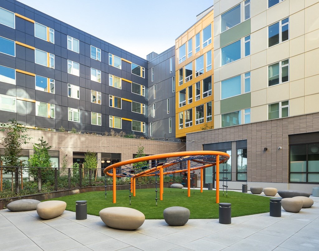 an outdoor courtyard of an office building with an orange swing