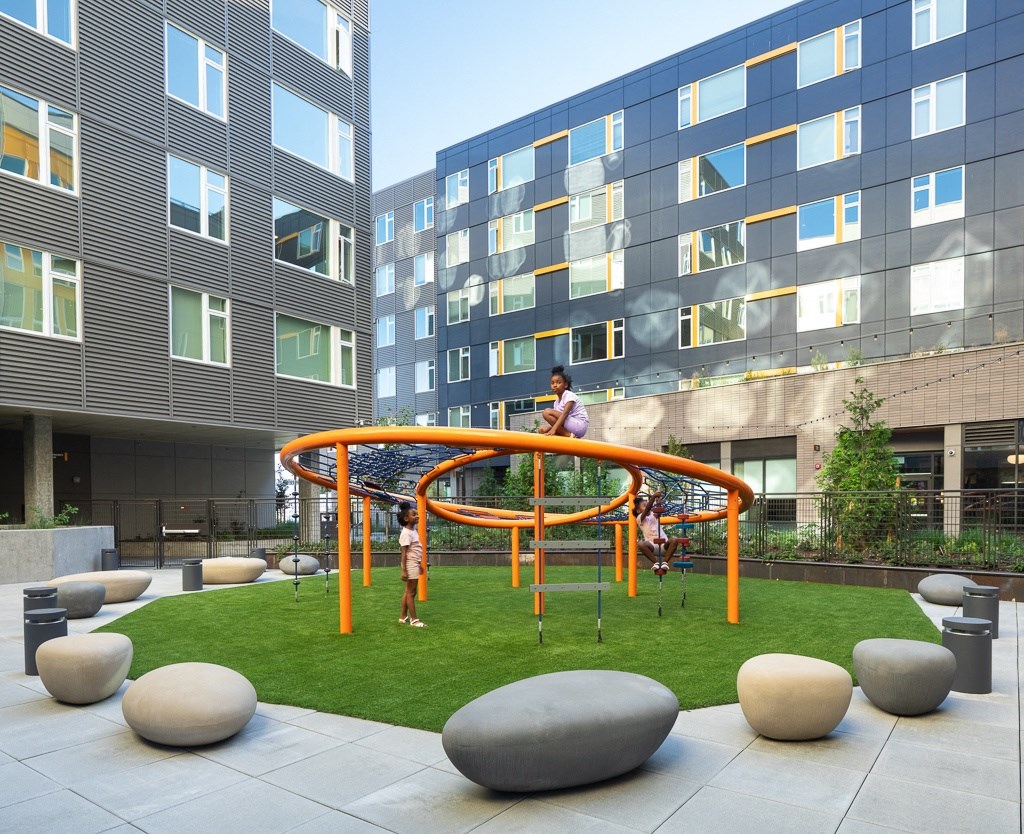 people playing on a playground in front of an office building