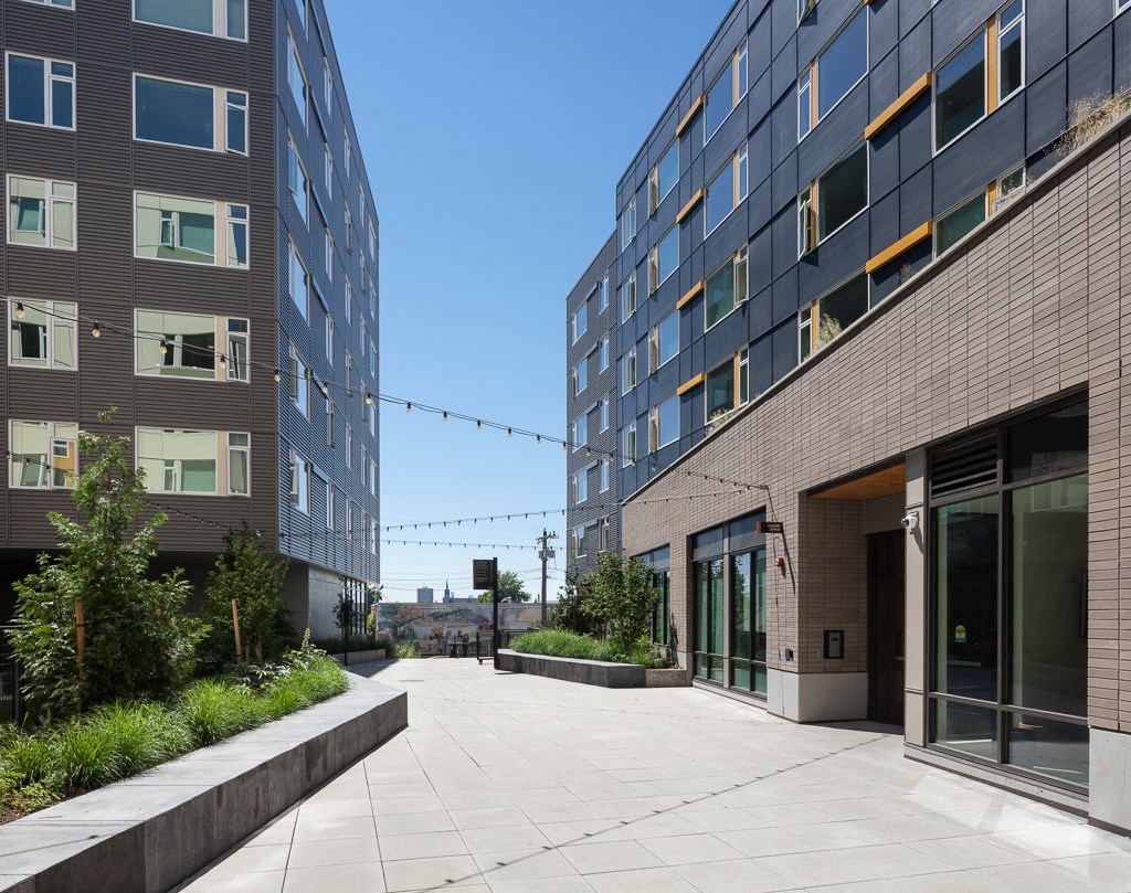 a courtyard between two tall buildings with a blue sky background