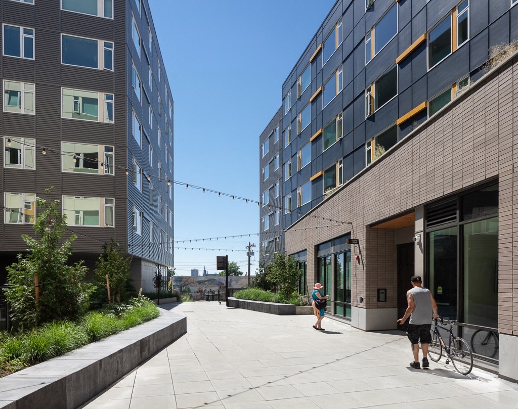 people walking on a sidewalk in front of a building