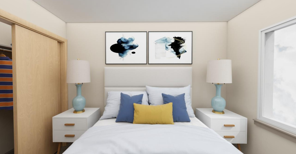 a bedroom with a bed and two paintings on the wall