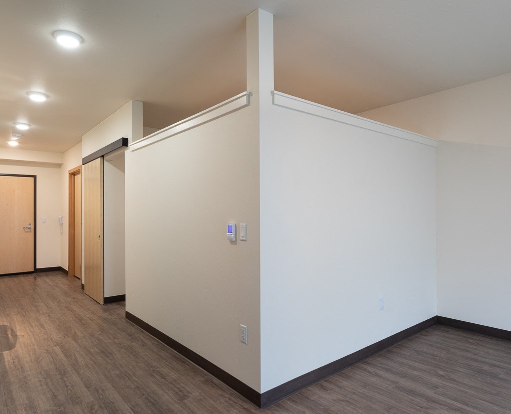 an empty room with white walls and wood floors