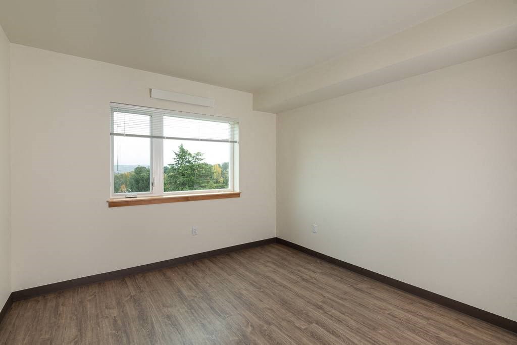 an empty room with wood floors and a window