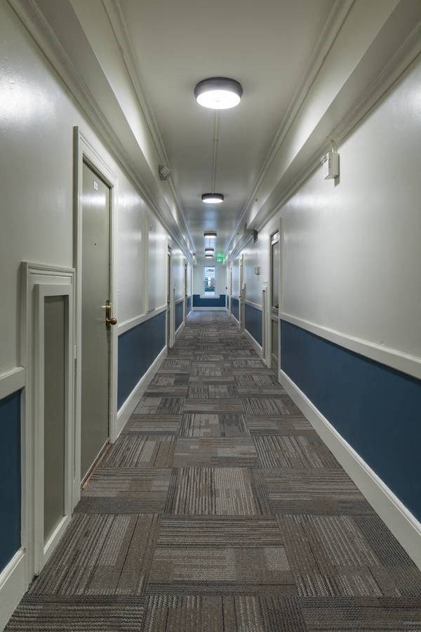 long hallway with blue and white walls and a carpeted floor at Cambridge Apartments, Seattle