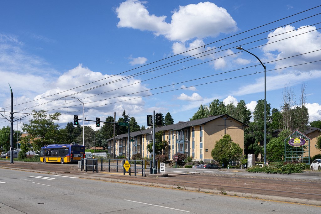 a bus is stopped at an intersection in front of a building