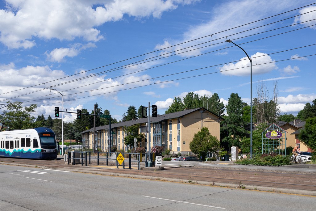 a train is stopped at an intersection in front of a building