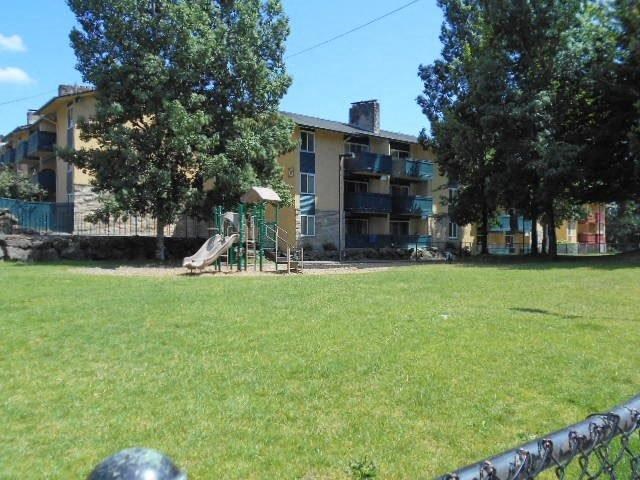 a yard with a playground and an apartment building