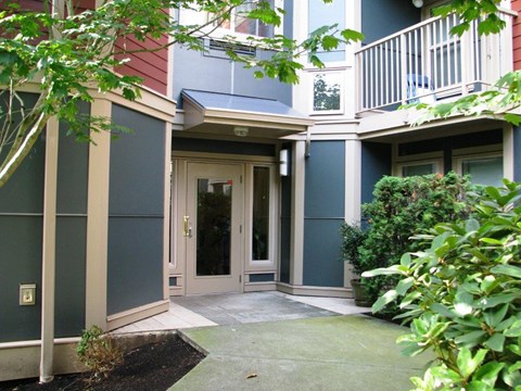 A building with a green bush in front of it.