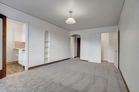 A room with a grey carpet and white walls.