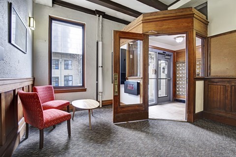 A room with a red chair and a wooden door.
