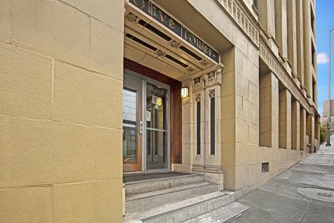 The entrance to a building with a glass door and a sign above it.