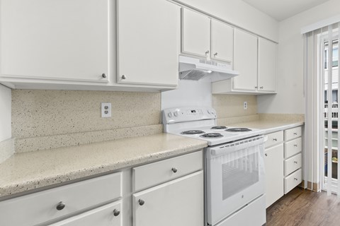 A white kitchen with a stove and cabinets.