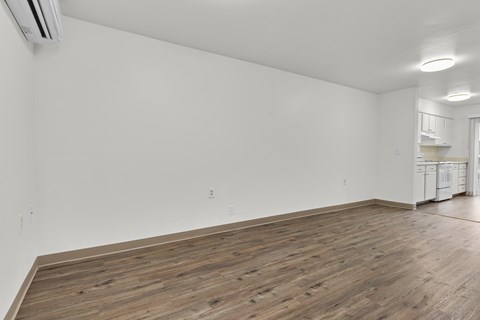 A room with wooden flooring and white walls.