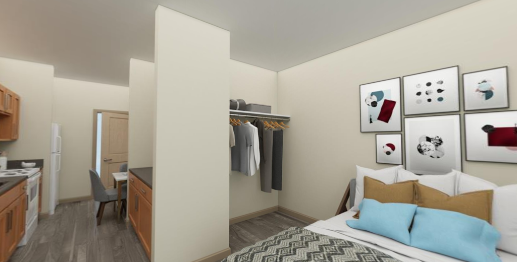 a bedroom with a bed and a desk in a room