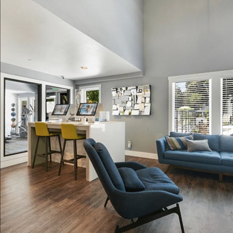 A modern living room with a blue couch and a yellow chair.