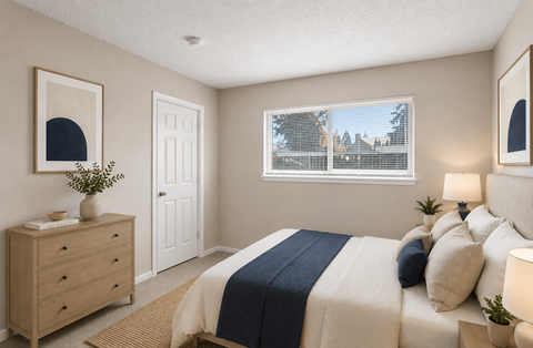 A bedroom with a bed, nightstand, and window.
