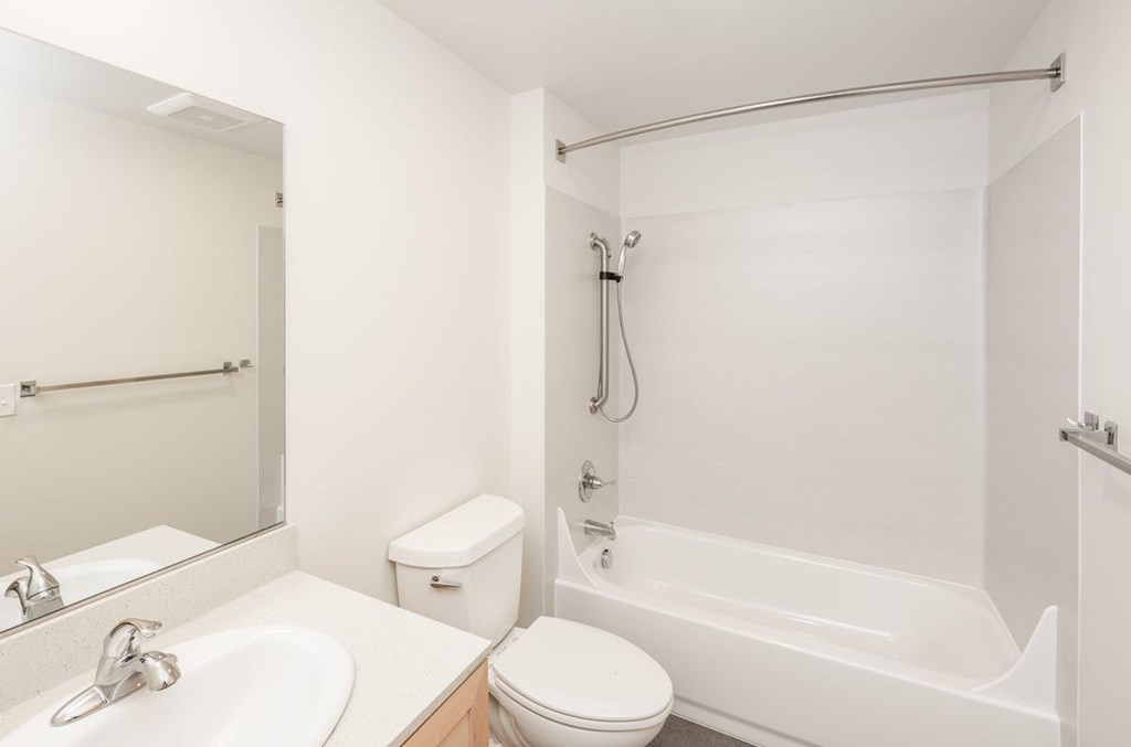 A white bathroom with a toilet, sink, and bathtub.