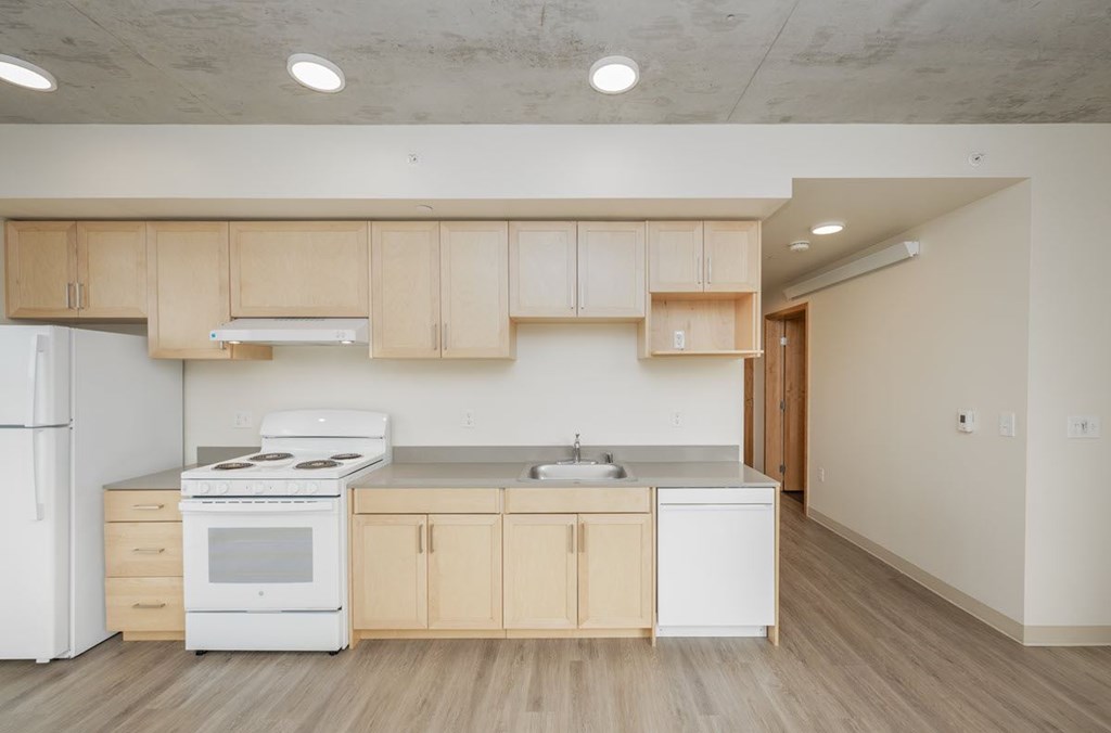 A kitchen with white appliances and wooden cabinets.