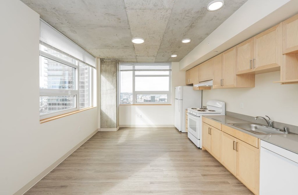 A kitchen with white appliances and wooden cabinets.