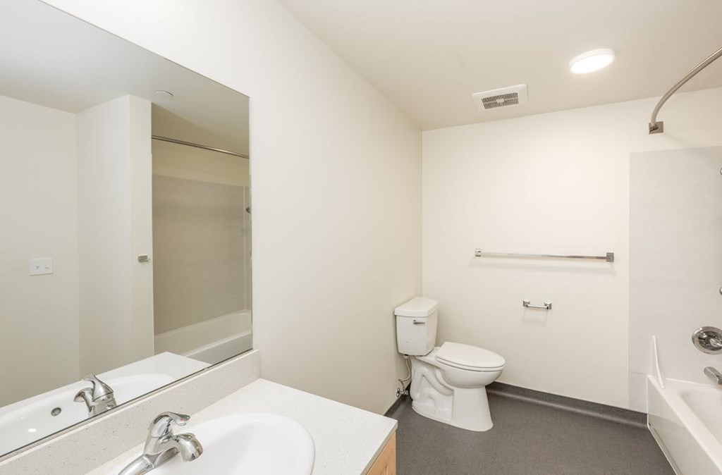 A white bathroom with a toilet, sink, and bathtub.