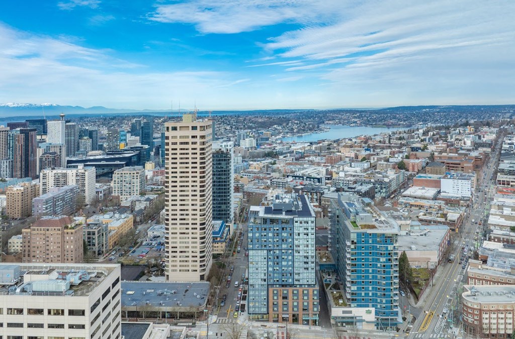 A cityscape with a mix of modern and older buildings under a clear sky.