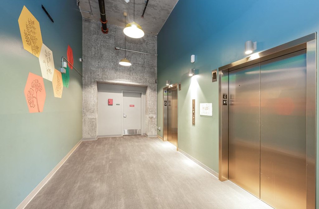 A hallway with a blue wall and a white door.