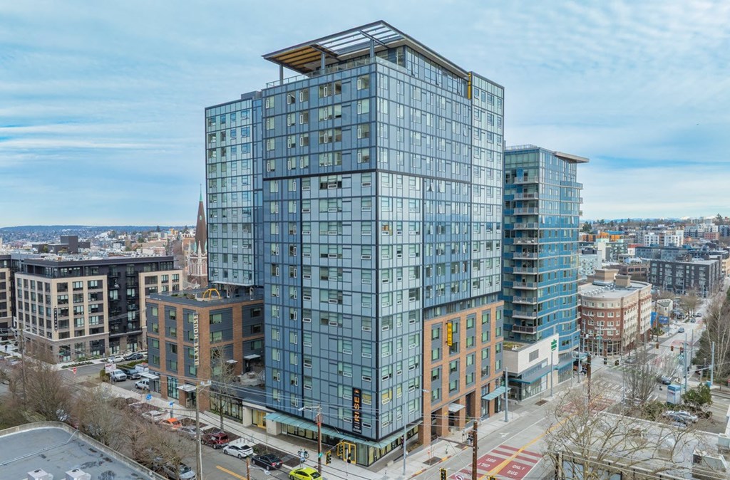 A modern glass building stands tall in a cityscape.