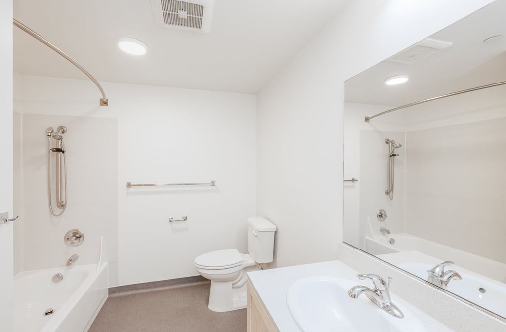 A white bathroom with a toilet, sink, and bathtub.