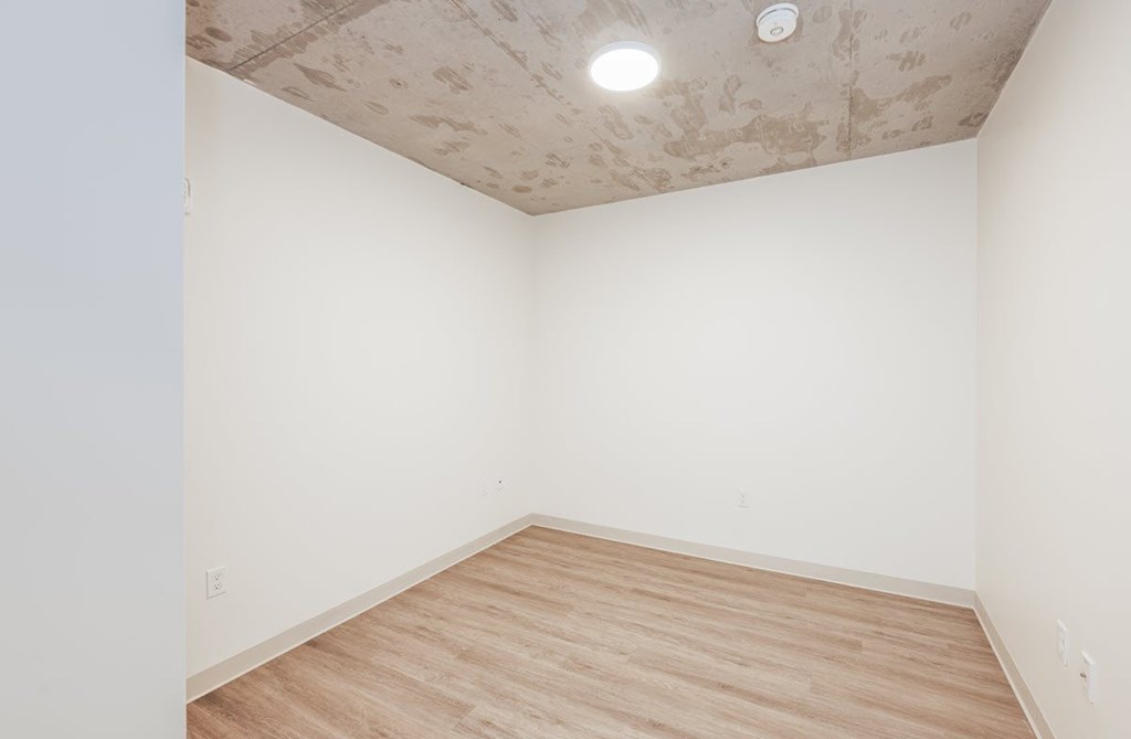 A room with a wooden floor and a ceiling with stains.