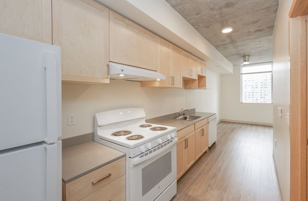 A kitchen with a white fridge, stove and oven.