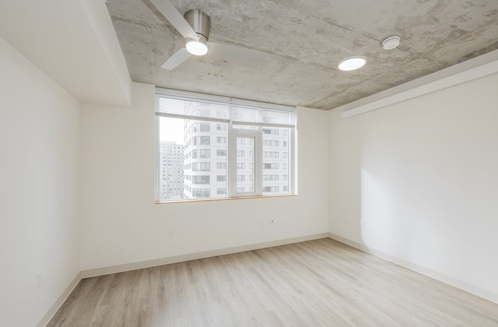 A room with a window and a ceiling fan.