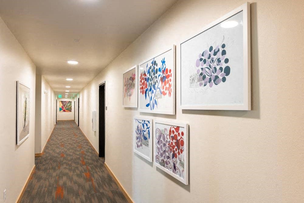 a hallway with paintings on the wall and a carpet at Arbora Court, Seattle, 98105