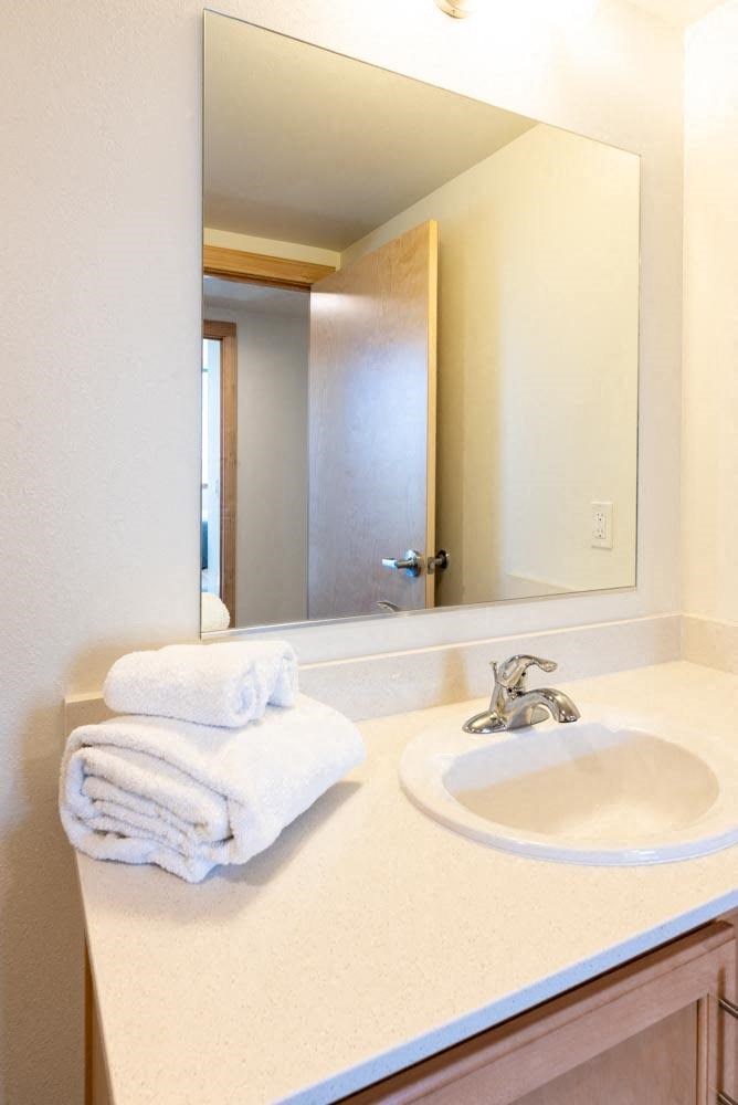 a bathroom with a sink and a large mirror at Arbora Court, Seattle, WA