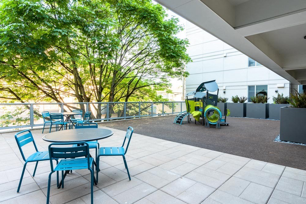 a patio with tables and chairs and a tractor in the background at Arbora Court, Seattle